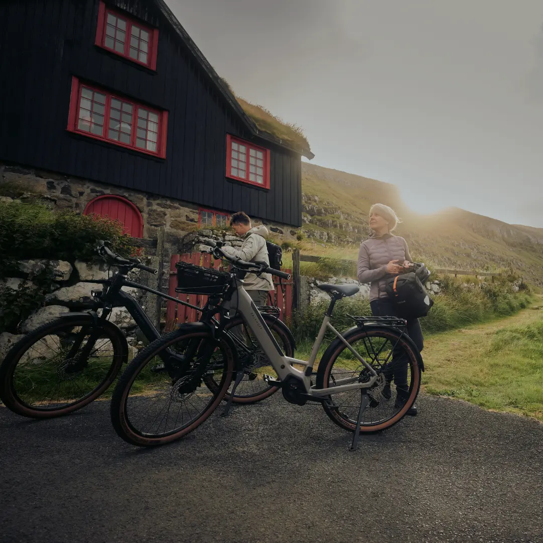 Trekking E-Bikes Zwei Trekking E-Bike Fahrer die gerade pausieren und neben den Fahrrädern stehen