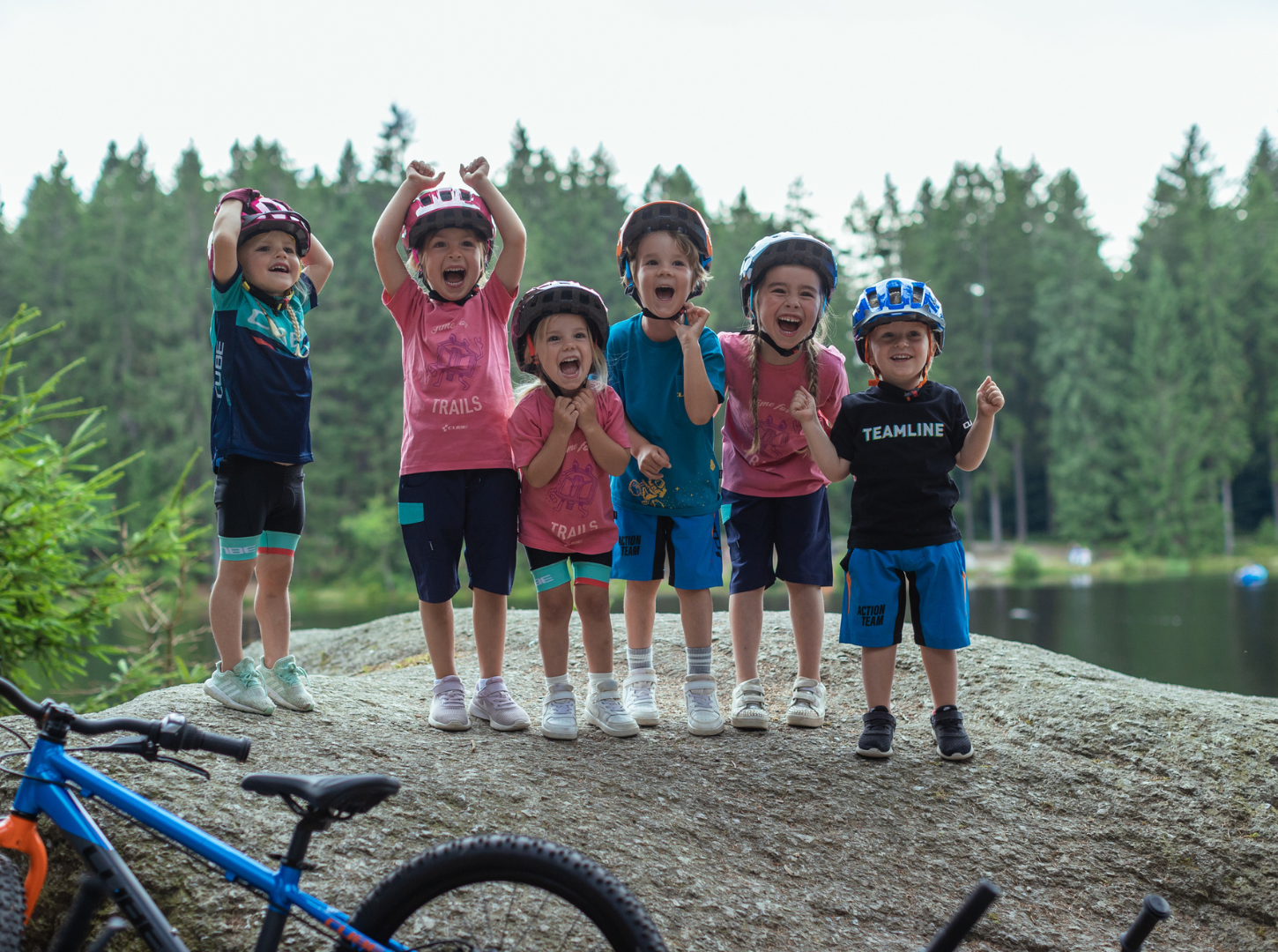 Glückliche Kinder mit Fahrradhelmen, die sich freuen