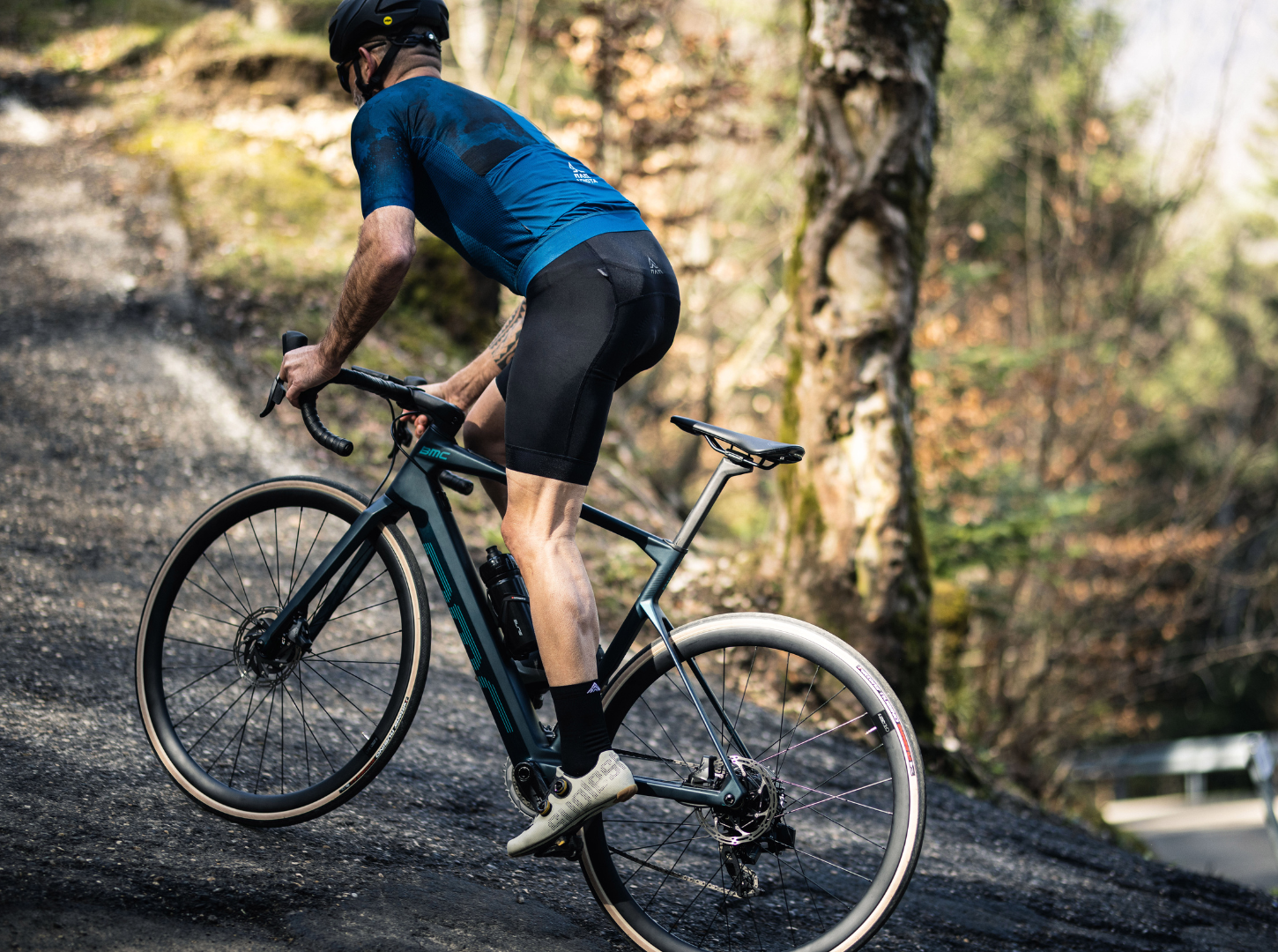 E-Rennrad-Fahrer-bewältigt-eine-ansteigende-Straße-mit-der-BMC-Roadmachine-AMP-mit-Mahle-Hinterradm Ein ERennrad Fahrer bewältigt eine ansteigende Straße mit seiner BMC Roadmachine AMP mit Mahle Hinterradmotor
